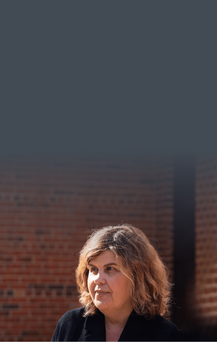 Carol, female patient with PBA in his 60s, standing in front of a mountainous landscape